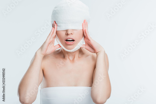 Wallpaper Mural scared woman with white bandages touching head isolated on white Torontodigital.ca