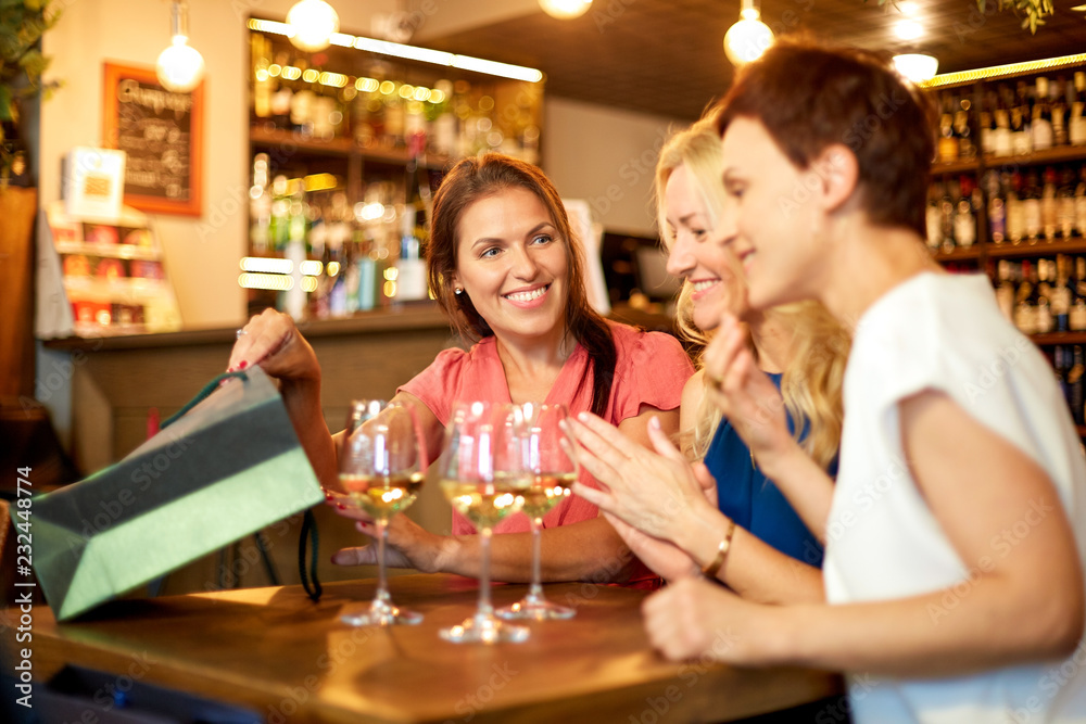 people, leisure and lifestyle concept - women with shopping bags at wine bar or restaurant