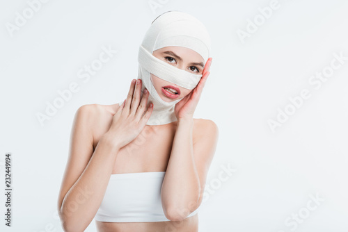 Murais de parede woman with bandages after plastic surgery touching head isolated on white