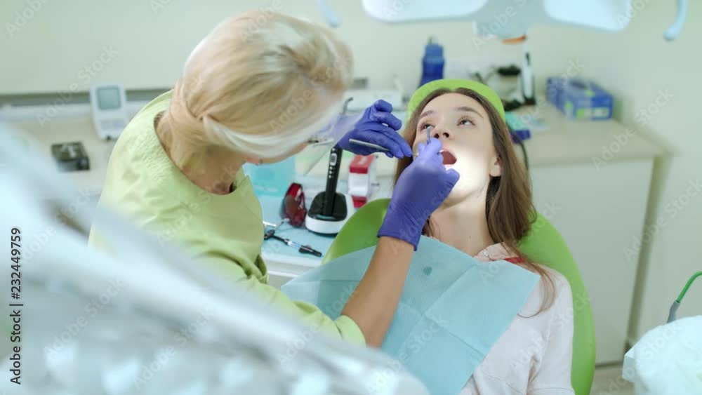 Stomatology doctor working in dental clinic. Female patient on review