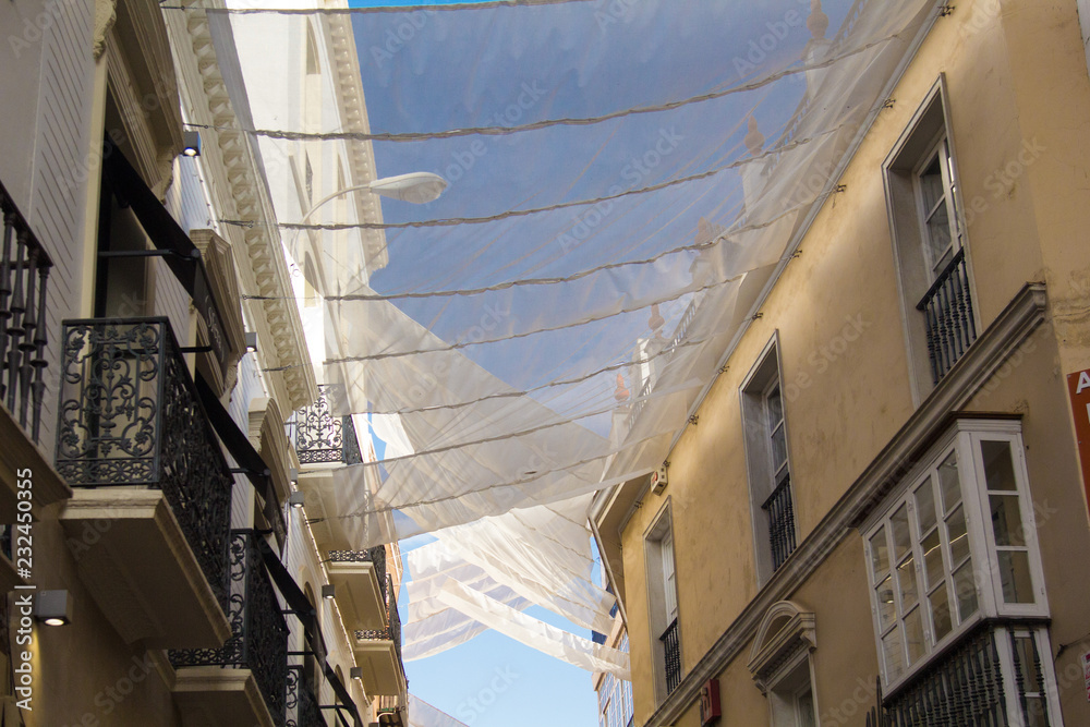 Obraz premium Shadow curtains on the street in Seville, Spain protecting tourists from sun and heat.