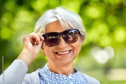 old age, eyewear and people concept - portrait of happy senior woman in sunglasses at summer park