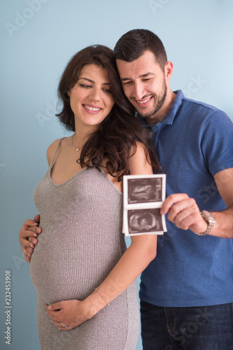 couple looking ultrasound picture isolated on blue background