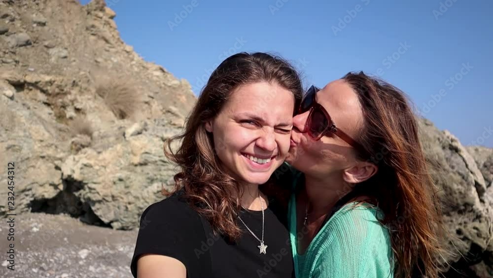 A young lesbian couple is taking selfie smiling hugging. A young lesbian couple is taking selfie smiling hugging.