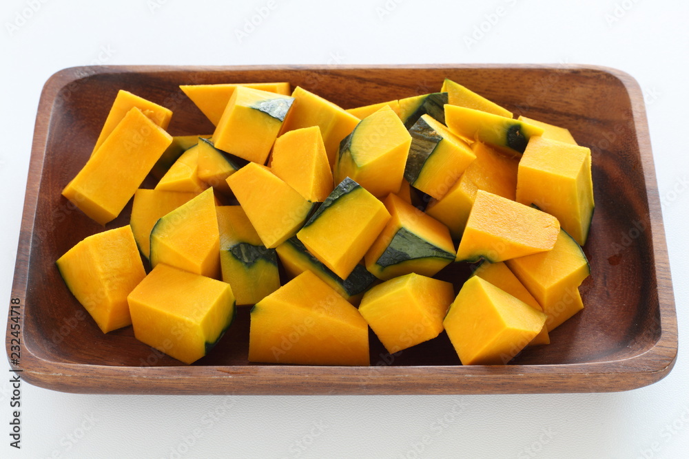 Chopped pumpkin on wooden plate Chopped pumpkin on wooden plate