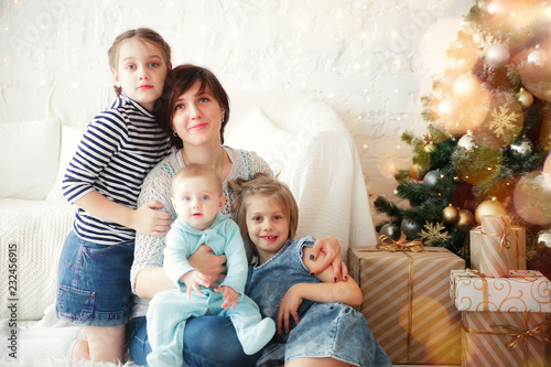 Mom with children on   floor in   room with   Christmas