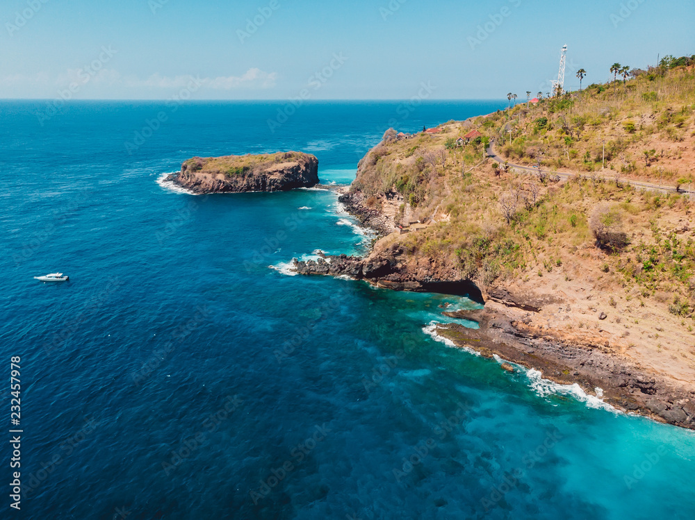 Blue ocean with rocky coast and island. Aerial view.