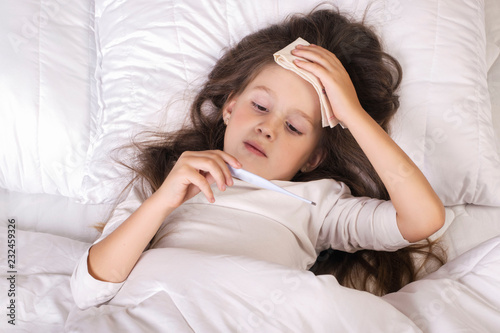 Sick Little Girl in Bed with Thermometer 