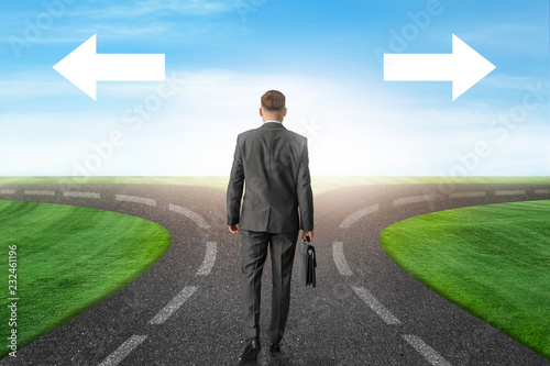 Slika na platnu Businessman standing at crossroads with arrows. Concept of choice