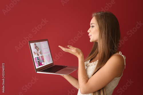 Young woman with laptop usi...