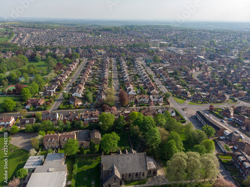 Typical UK Town aerial photo showing rows of houses, roads, parks and communal area