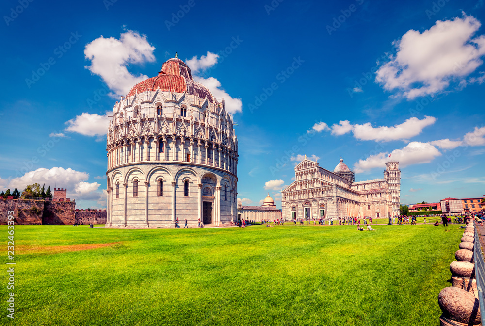 Picturesque spring view of famous Leaning Tower in Pisa. Sunny morning scene with hundreds of tourists in Piazza dei Miracoli (Square of Miracles), Italy, Europe. Traveling concept background.