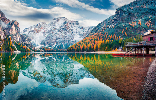 Boat hut on Braies Lake with Seekofel mount on background. Colorful autumn sunrise of Italian Alps, Naturpark Fanes-Sennes-Prags, Dolomite, Italy, Europe. Traveling concept background.