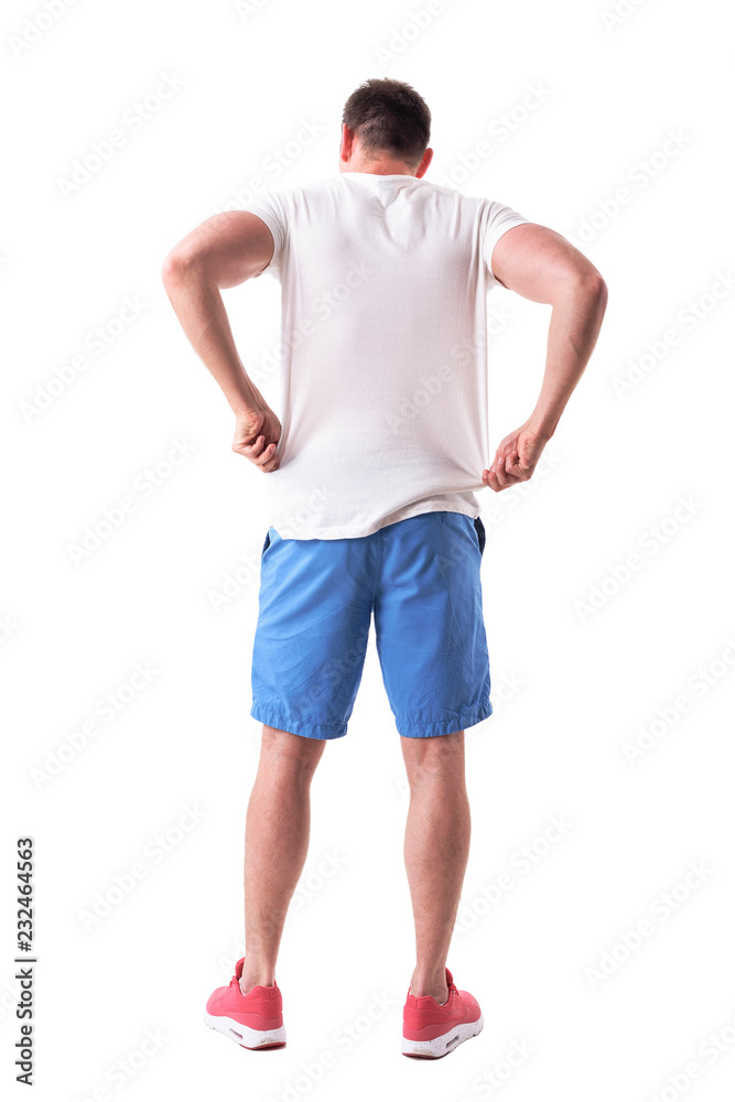 Back view of young handsome man adjusting and putting on summer clothes. Full body isolated on white background. Back view of young handsome man adjusting and putting on summer clothes. Full body isolated on white background.