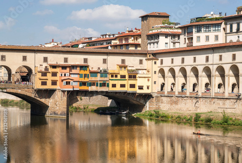 Riverboat with floating on river Arno near famous bridge of ancient Tuscany city