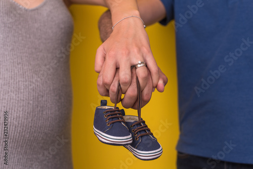 couple holding newborn baby shoes
