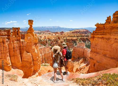 Fototapeta Couple on hiking trip looking at beautiful  mountain landscape,  Friends  relaxing on top of the mountain