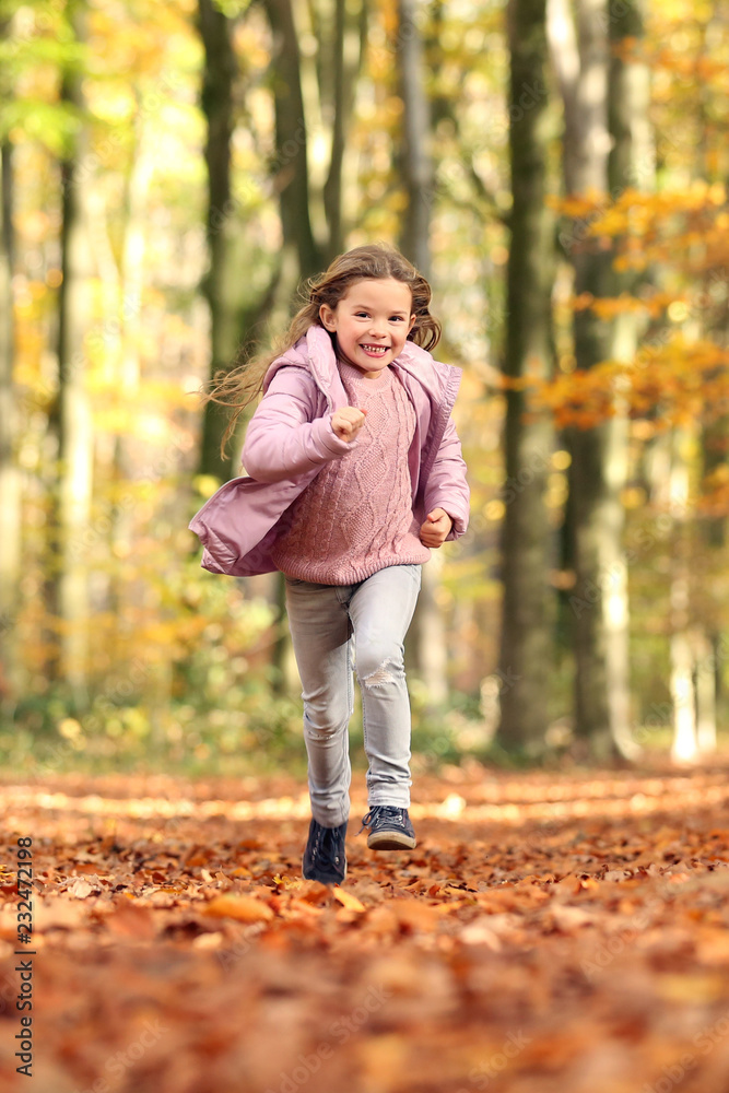 Kleines Mädchen rennt durch einen herbstlichen Wald Kleines Mädchen rennt durch einen herbstlichen Wald