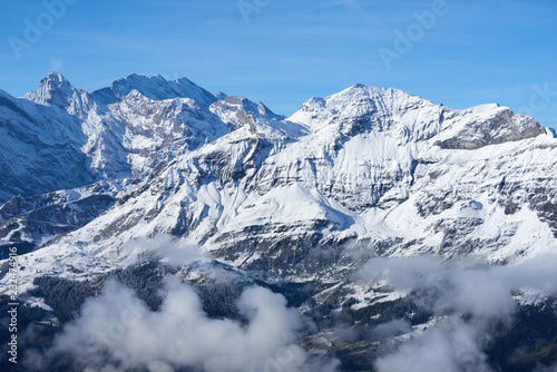 Winter mountain snowy peaks over clouds in the valley. Jungfrau region in Switzerland. © thecolorpixels