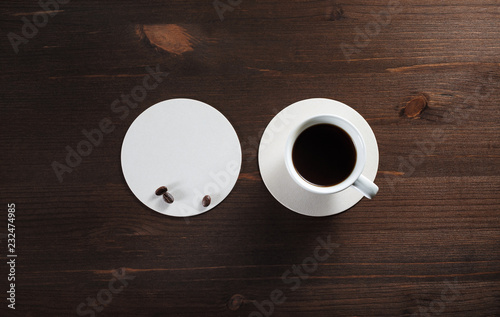 Cup of coffee and beer coaster on wood table background. Flat lay.