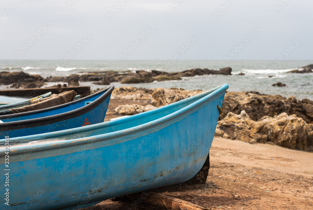 Naklejka premium Fishing boat docked on a rocky shore in Vagator Goa