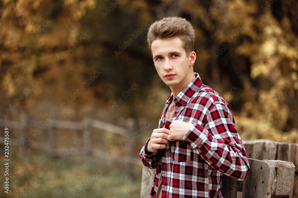 Handsome young guy in nature on an autumn day