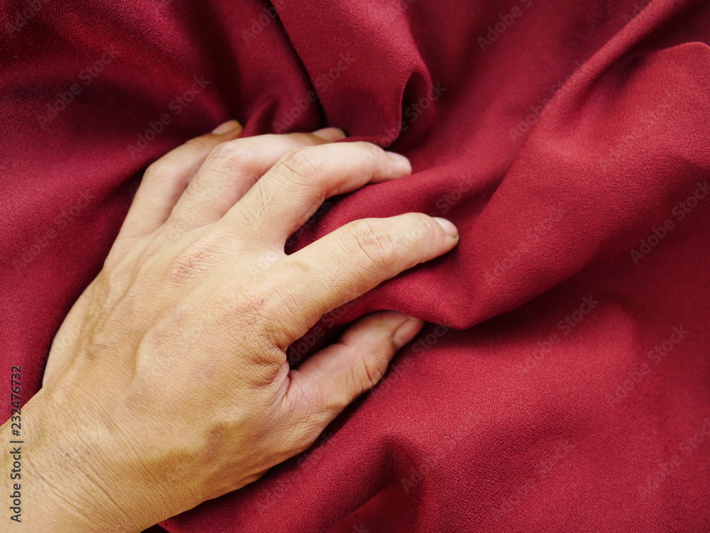 Fototapeta premium human hand on red cloth,cotton fabric background,red silk satin