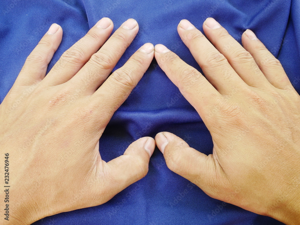 Fototapeta premium women hand on blue cloth background,texture of silk fabric