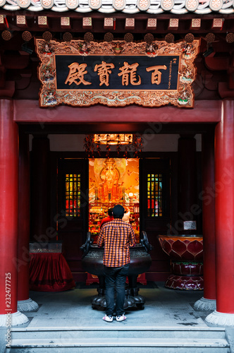 Photography Man praying in Singapore Buddha Tooth relics temple with Chinese Architecture
