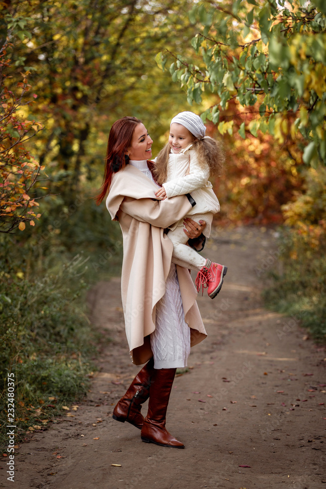 charming beautiful mother walks with little daughter girl