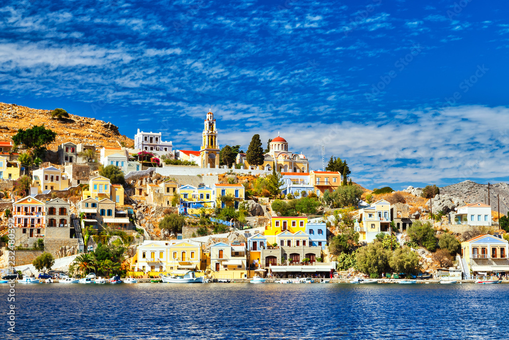 Multi-colored houses on the shore of the bay in the city of Simi on the Greek island of the same name in the Aegean Sea