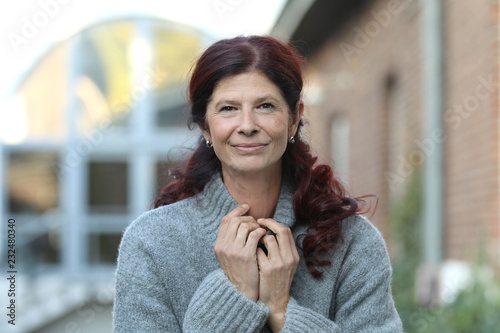 Ältere rothaarige Frau mit Pullover bekleidet