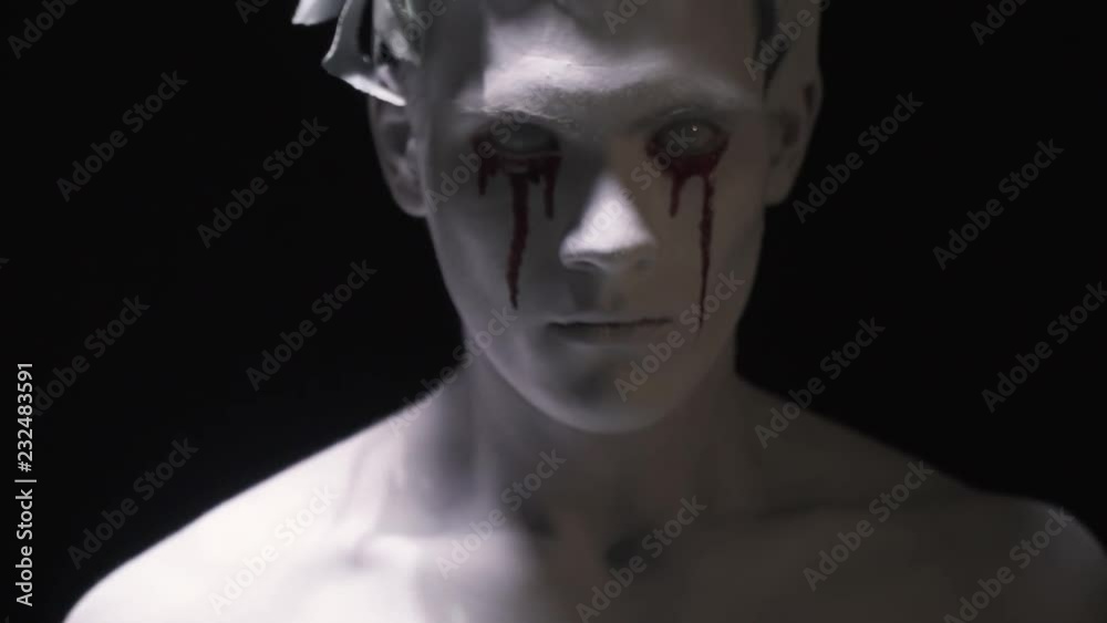 Bloodied face of the living statue with laurel wreath on his head Bloodied face of the living statue with laurel wreath on his head