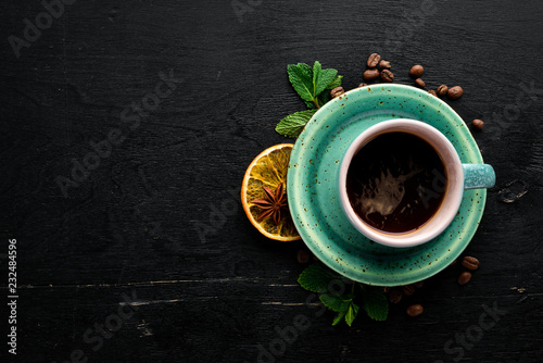 A cup of black coffee on a wooden background. Free space for your text. Top view.