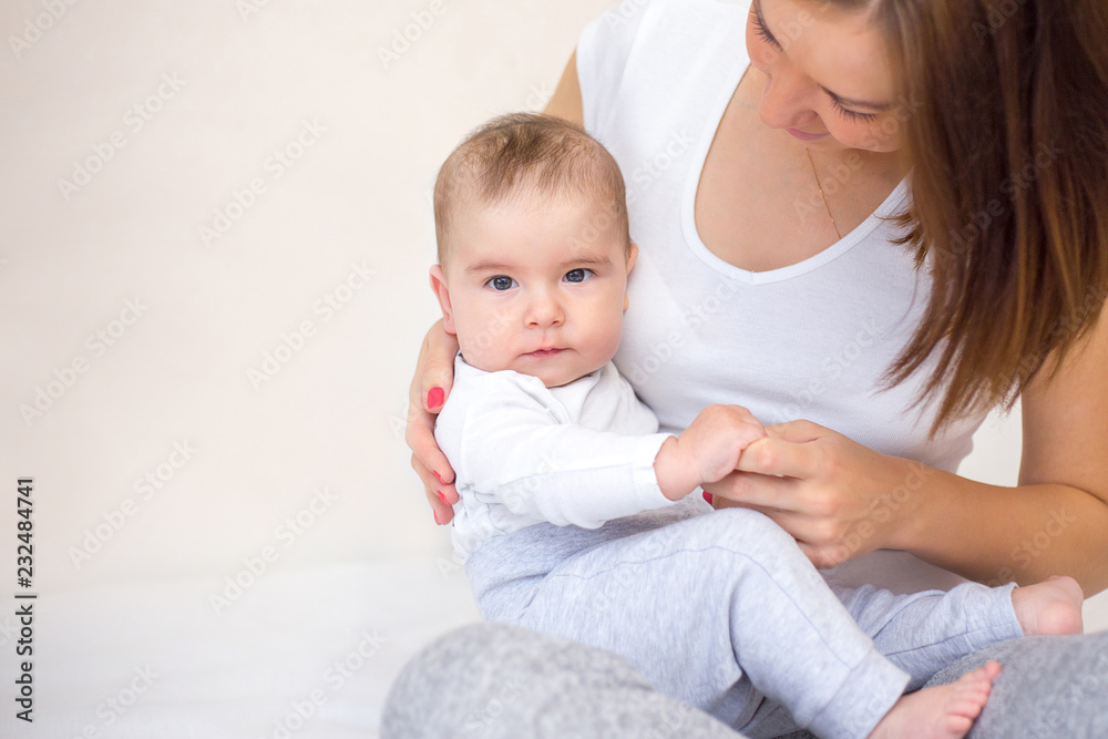 young mother is playing with her happy baby