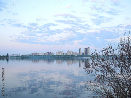 City Kiev skyline. View of the sleeping area across the river. Clouds reflected in water. © Deilline