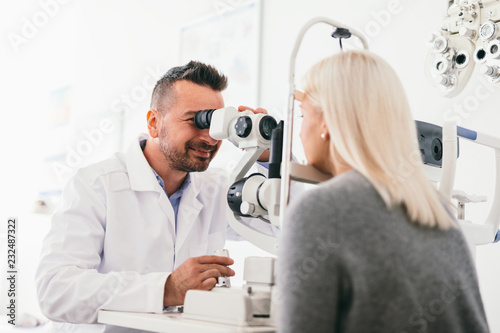 Optician examining woman's eyes with a machine. photo