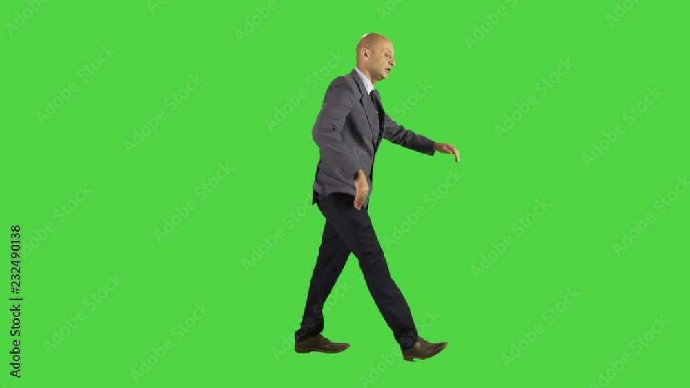 Businessman goofs around, send kisses to the camera, happy, wearing a suit. full sideways shot over a green screen. Businessman goofs around, send kisses to the camera, happy, wearing a suit. full sideways shot over a green screen.