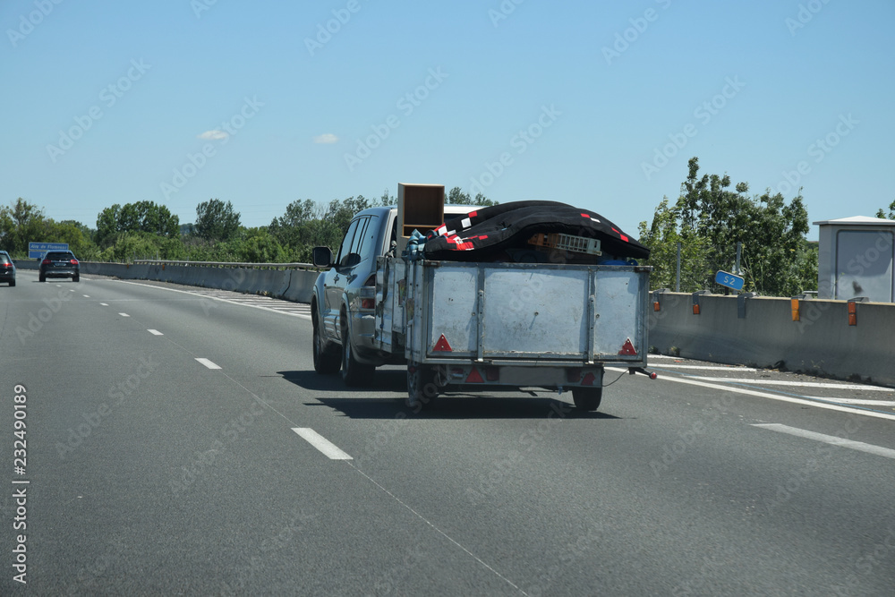 Remorque chargée tirée par une voiture sur l'autoroute A9 languedocienne dans l'Hérault