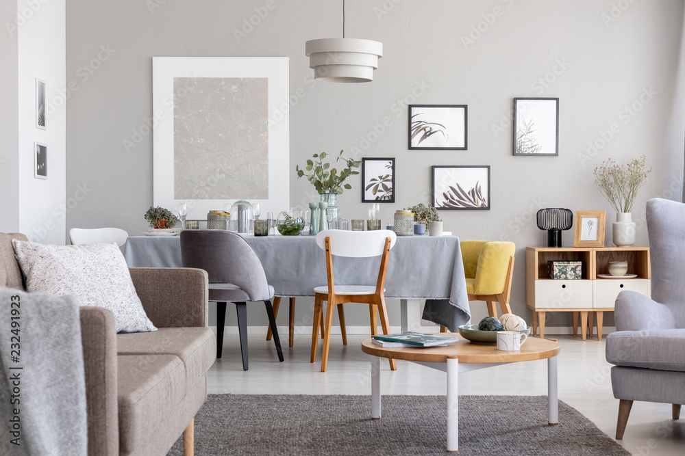 Elegant living room interior with sofa, dark carpet, simple gallery and dining table set for holiday celebration in the real photo