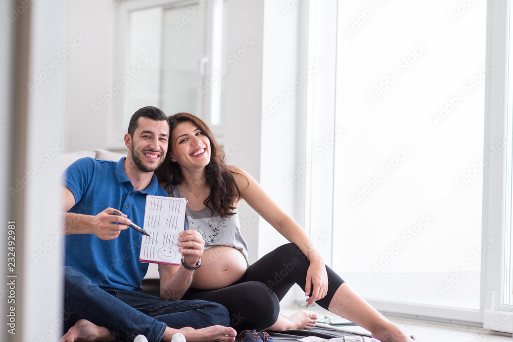 pregnant couple checking a list of things for their unborn baby