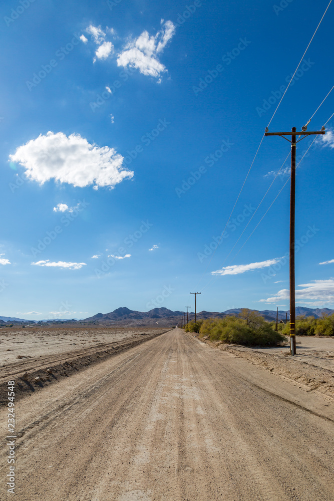 Looking along a long dusty unpaved road in rural California