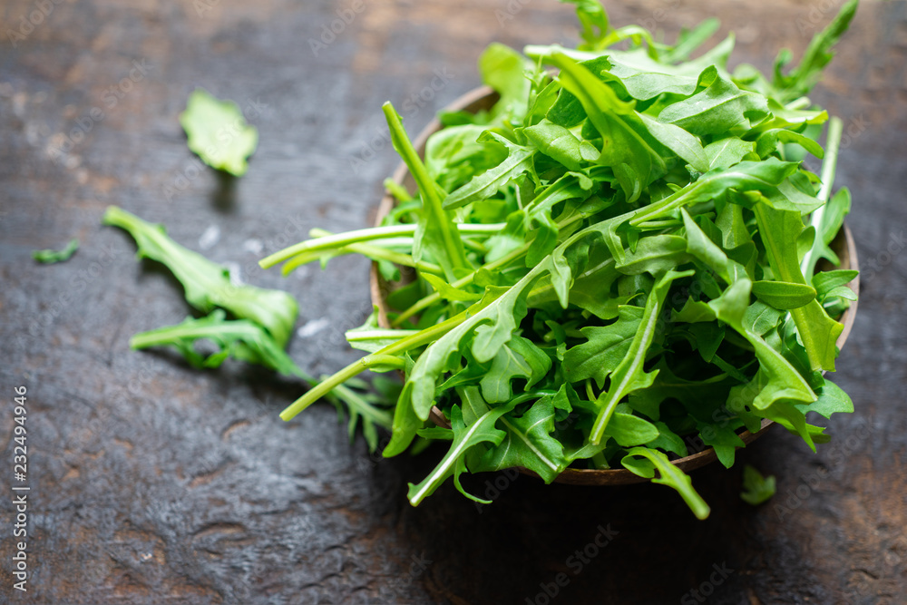 Fresh arugula salad,washed baby rocket on a wooden chopping board, breakfast healthy food.selective focus Fresh arugula salad,washed baby rocket on a wooden chopping board, breakfast healthy food.selective focus