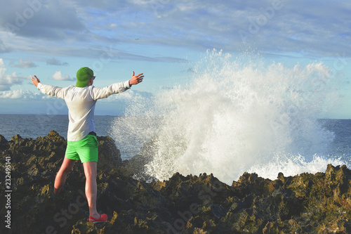 A person is standing on the hill beneath colorful sky and blow water. Clicked on the top of volcano Bali, Indonesia . photo