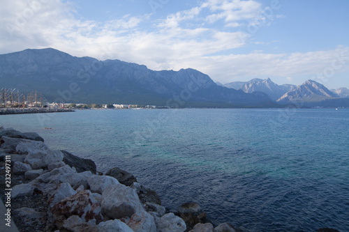  Rocks and a calm blue sea against the background of mountains. Landscape photo concept for screen savers and Wallpapers.