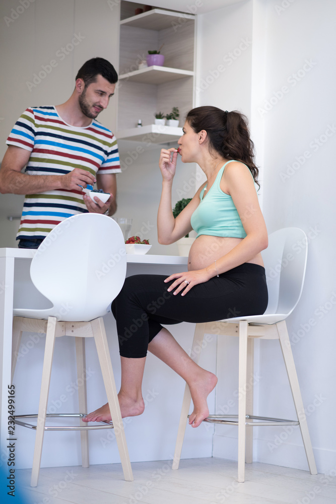 couple eating fruit strawberries at kitchen couple eating fruit strawberries at kitchen