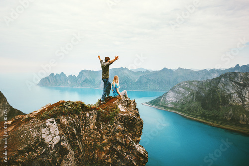 Travel couple enjoying view together on cliff edge in Norway man and woman family healthy traveling lifestyle summer vacations outdoor success friendship happy emotions