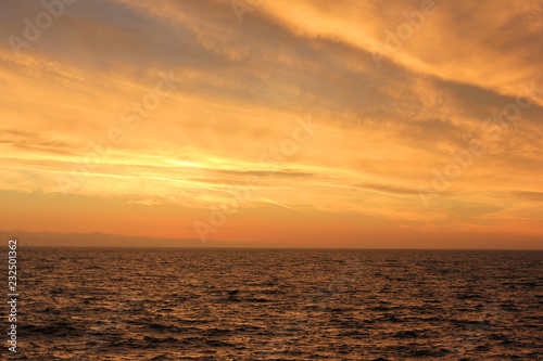 Sunset Sky Landscape Over Sea Water with Vibrant Orange Cloudscape. Scenic Empty Sky Background at Sunset or Sunrise, Dusk and Dawn Beautiful Skyline View with Still Water Perspective Panorama 