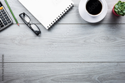Office desk table with smartphone, pen , cup of coffee and eye glasses. Top view with copy space