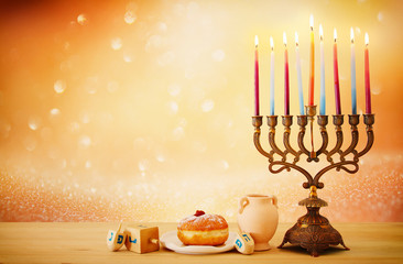 image of jewish holiday Hanukkah background with menorah (traditional candelabra) and candles over glitter shiny background.